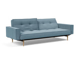 Splitback Styletto Light Wood sovesofa med armlæn i 525 Mixed Dance Light Blue, med den ene ryghalvdel lænet tilbage
