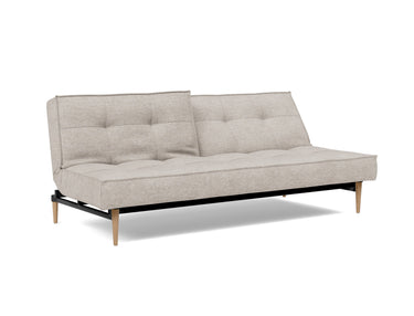 Splitback Styletto Light Wood sovesofa i 471 Yuveno Sand, med den ene ryghalvdel lænet tilbage