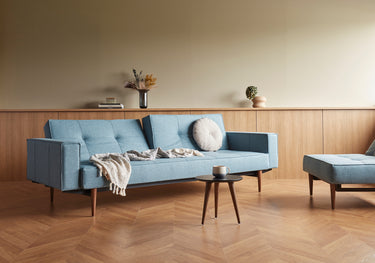 Splitback Styletto Dark Wood sovesofa med armlæn i 525 Mixed Dance Light Blue i en stue